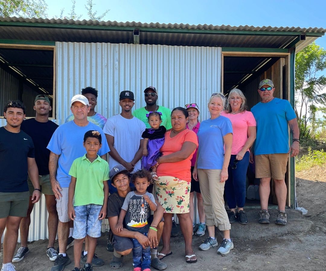 Our team with a family in front of a home we helped build